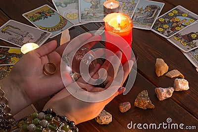 Bangkok,Thailand,March.15.20.The girl holds wedding rings on her hand with Tarot cards with heart,crystals,a magic ball and a Editorial Stock Photo