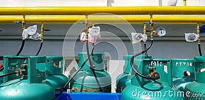 Group of new green gas tank install with value, yellow pipe or pipeline and white wall background. Editorial Stock Photo