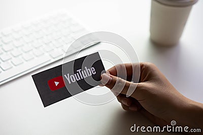 Bangkok, Thailand - May 2, 2019 : hand is pressing screen displays the Youtube app icons on paper label. Editorial Stock Photo