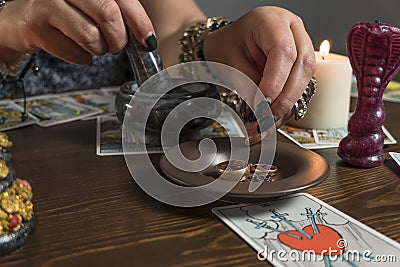 Fortune teller medium lays out Tarot cards and guesses for the future with wedding ring. Stock Photo