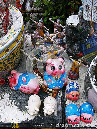 Small figures of dancers and pigs deposited as an offering at the Pig Memorial. Bangkok Pig Monument Editorial Stock Photo