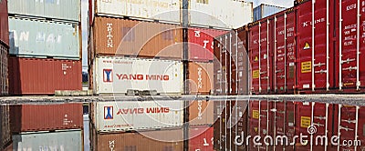 Stacked shipping containers reflect in puddle Editorial Stock Photo