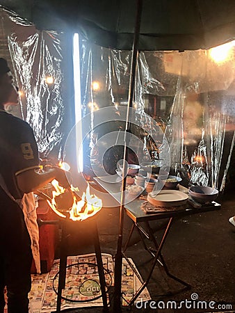 Bangkok, Thailand - November 10, 2019: Street food cooking with fire in Yaowarat Chinatown Street Food Market Editorial Stock Photo