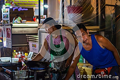 BANGKOK, THAILAND - NOVEMBER 2018: Thai muslim couple are preparing and cooking thai food in the evening on the night market Editorial Stock Photo