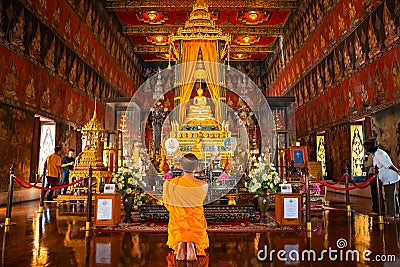 Bangkok, Thailand - November 11 2019: Unidentified Buddhist monk pays respect to the Buddha Sihing statue inside the Phutthai Editorial Stock Photo