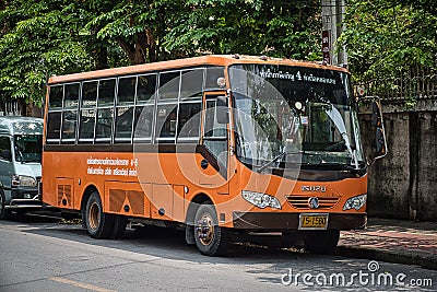 Old orange retro bus parking on the side of a quiet street of Bangkok Editorial Stock Photo
