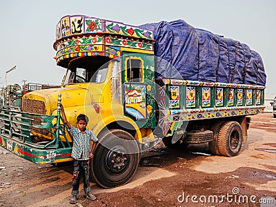 Bangladesh kid and colourful freight carrier truck on dirt road of Dhaka city Editorial Stock Photo