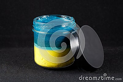 Bank of color slime, the flag of Ukraine, on a black background. Close-up Stock Photo