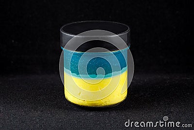 Bank of color slime, the flag of Ukraine, on a black background. Close-up Stock Photo