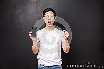 Bank, finance and payment concept. Impressed overwhelmed young asian man promote credit card service features, banking Stock Photo