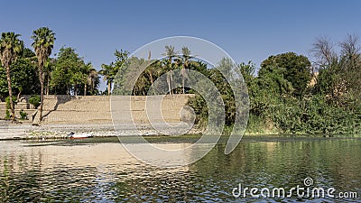 The bank of the Nile is fortified with a stone wall. Stock Photo