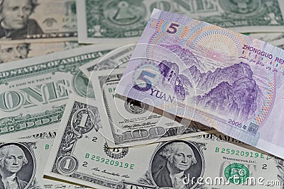 Banknote of five Chinese yuan against background of american dollars Stock Photo