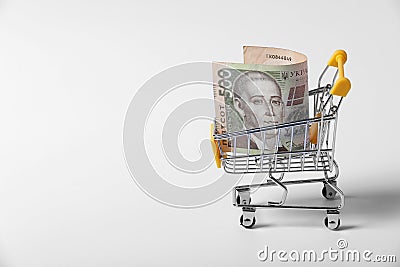 Banknote Ukrainian hryvnia in the shopping cart on shopping isolated on white background. close-up of shopping trolley. business Stock Photo