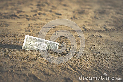 Banknote of value of one dollar in the the sand on the beach. Concept of cheap travel and vacation. Stock Photo