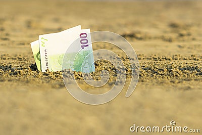 Banknote of value of one hundred euro in the the sand on the beach. Concept of cheap travel and vacation. Stock Photo