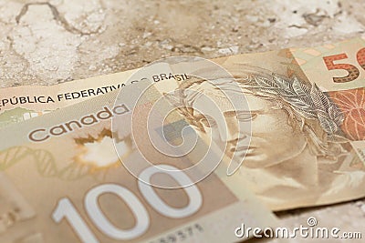 Banknotes of canadian currency: Dollar and brazilian Currency: R Editorial Stock Photo