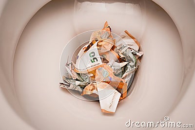 Banknotes dollars and euros are thrown into the toilet and washed off with water Stock Photo