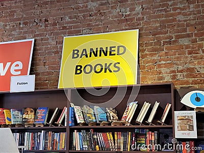 Banned Books sign above book titles on shelf Editorial Stock Photo