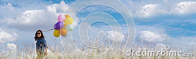 Banner Cheerful cute girl holding balloons running green meadow white cloud and blue sky with happiness. Panorama Hands holding Stock Photo