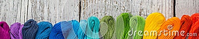 Banner of colorful sewing threads for embroidery on white wooden background Stock Photo