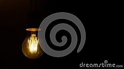 Banner copy space. Dim light bulb on a black background. Gloomy black background. Old dirty lamp Stock Photo