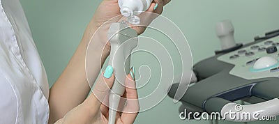 banner with a doctor in a medical gown applies gel to an ultrasound machine for human organs. Stock Photo