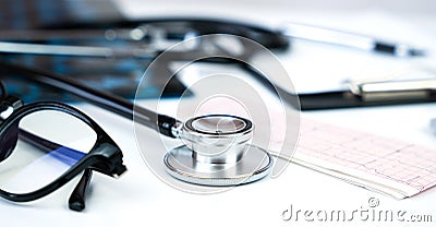 Banner. Doctor`s workplace with stethoscope, clipboard, glasses and pills. Close-up. Selective focus Stock Photo