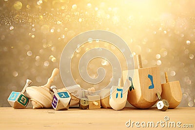 Banner of jewish holiday Hanukkah with wooden dreidels & x28;spinning top& x29; over glitter shiny background. Stock Photo