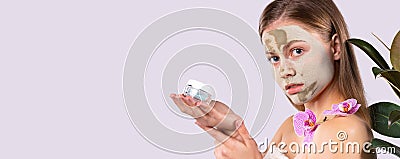 Banner- long format on grey background. Cute woman facial fresh mask. Expressive pointing to the side holding cosmetic Stock Photo