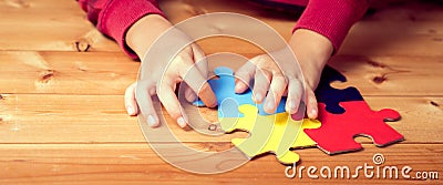 Banner picture of an autistic child`s hands playing a puzzle symbol of Public awareness for autism Stock Photo