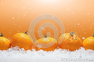 Banner with tangerines in the form of fur-tree toys on the snow, with falling snow. Happy Christmas or Happy New Year, orange Stock Photo