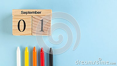 Banner with a wooden September 1 calendar, colored pens on a blue background. Copy space. beginning of the school year Stock Photo