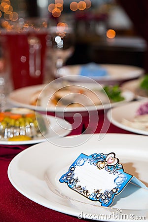 Banquet cards for Seating guests. Side view. Banquet card on a white dish. Festive table. Decorated table for a Banquet. Backgroun Stock Photo