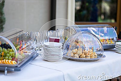 Banquet table for a banquet in a restaurant.snacks, cakes, empty glasses, tableware, plates,fruit on a plate Stock Photo