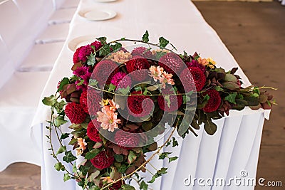 Banquet table decorated with red dahlias and another flowers. Stock Photo