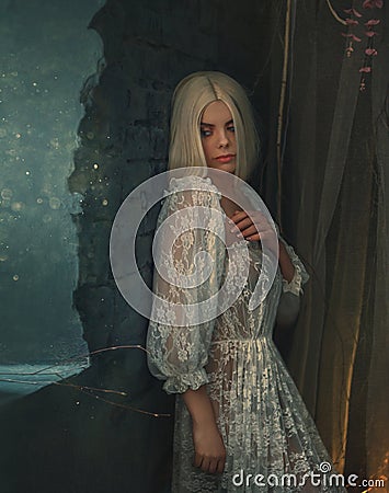Banshee fairy. Pale blonde girl in white vintage dress. Seductive princess, with sexy, long legs posing against the Stock Photo