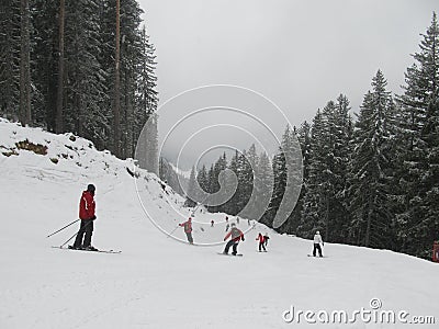 View of the ski slope in cloudy weather and a snowstorm, a lot of skiers and snowboarders on the descent Editorial Stock Photo