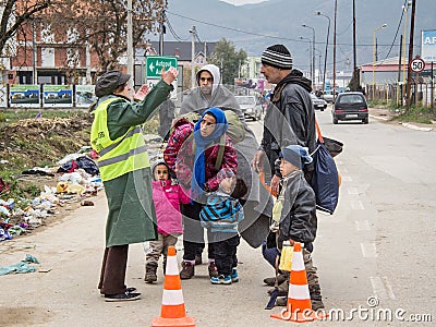 Family of refugees discussing with a NGO volunteer on their way to register and enter Serbia at border with Macedonia Editorial Stock Photo