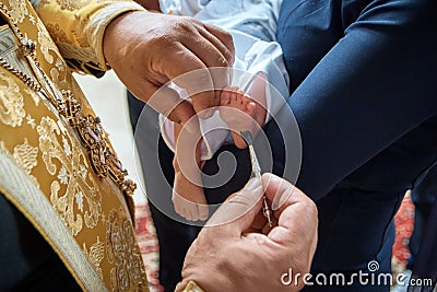 Baptism, anointing of a child. Christian customs Two hands and a church brush. Stock Photo