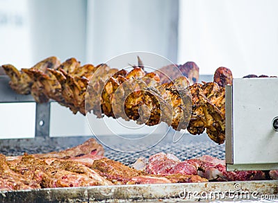 Barbecue chicken wings grilling in skewer machine. Stock Photo