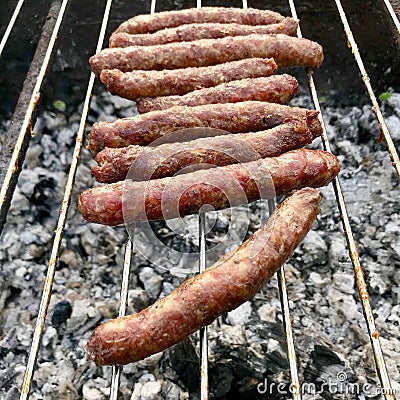 Barbecue with fiery Bavarian sausages on grill in garden outdoors Stock Photo