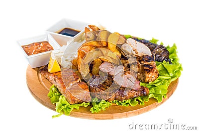 Barbecue pork, salmon steak, potatoes, salad and sauce Stock Photo