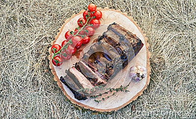 Barbecue ribs meat prepared in traditional European style with rosemary herb cherry tomatoes and garlic on a raw solid Stock Photo