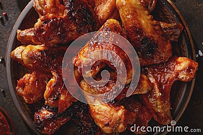 Barbecued chicken wings with bbq sauce on the plate top view. Stock Photo