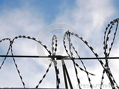 Barbed wire on the background blue sky. Prison concept, rescue, refugee, lonely, space for text Stock Photo