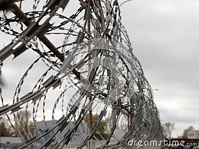 Barbed wire on background blue sky. Prison concept, rescue space for text Stock Photo