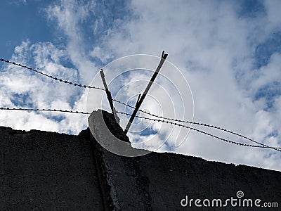 barbed wire close-up against a blue sky, the concept of incarceration, serving a sentence, restriction of freedom, isolation, crim Stock Photo