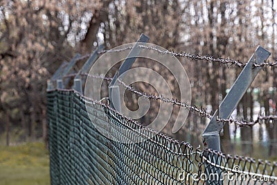 Barbed wire on a fence and steel lattice Stock Photo