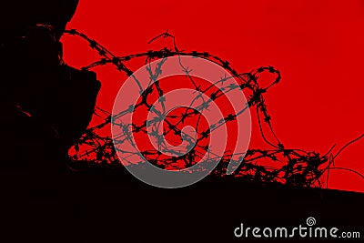 Barbed wire silhouette against red background Stock Photo