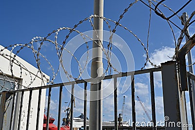 The barbed wire on top of the fence enclosing the passenger dock. Stock Photo